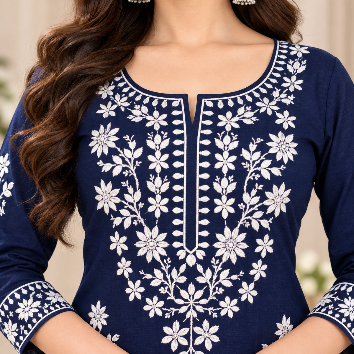 A woman models a navy blue salwar kameez suit with intricate white embroidery, matching patterned trousers, and a coordinating patterned dupatta in an indoor setting.