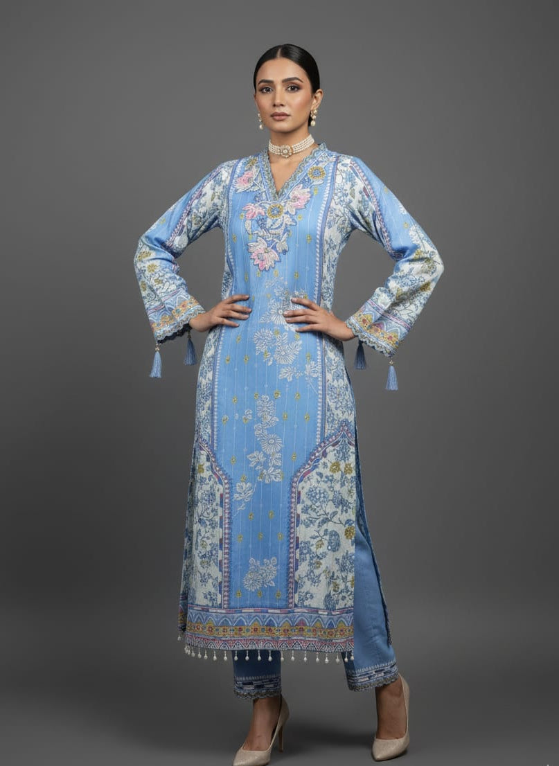 Woman wearing a traditional Pakistani outfit with floral patterns on a gray background