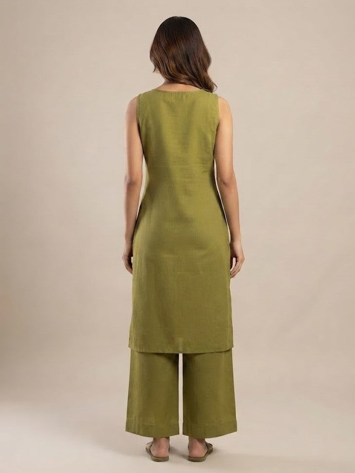 A woman modeling an olive green kurta and wide-leg pants set with floral embroidery, photographed against a solid beige studio background.